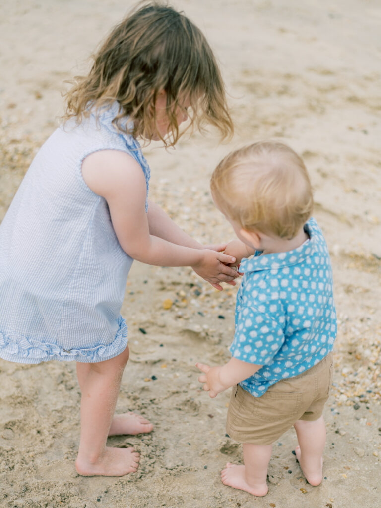 Sister and brother playing in sand at Richmond Virginia beach portrait session.