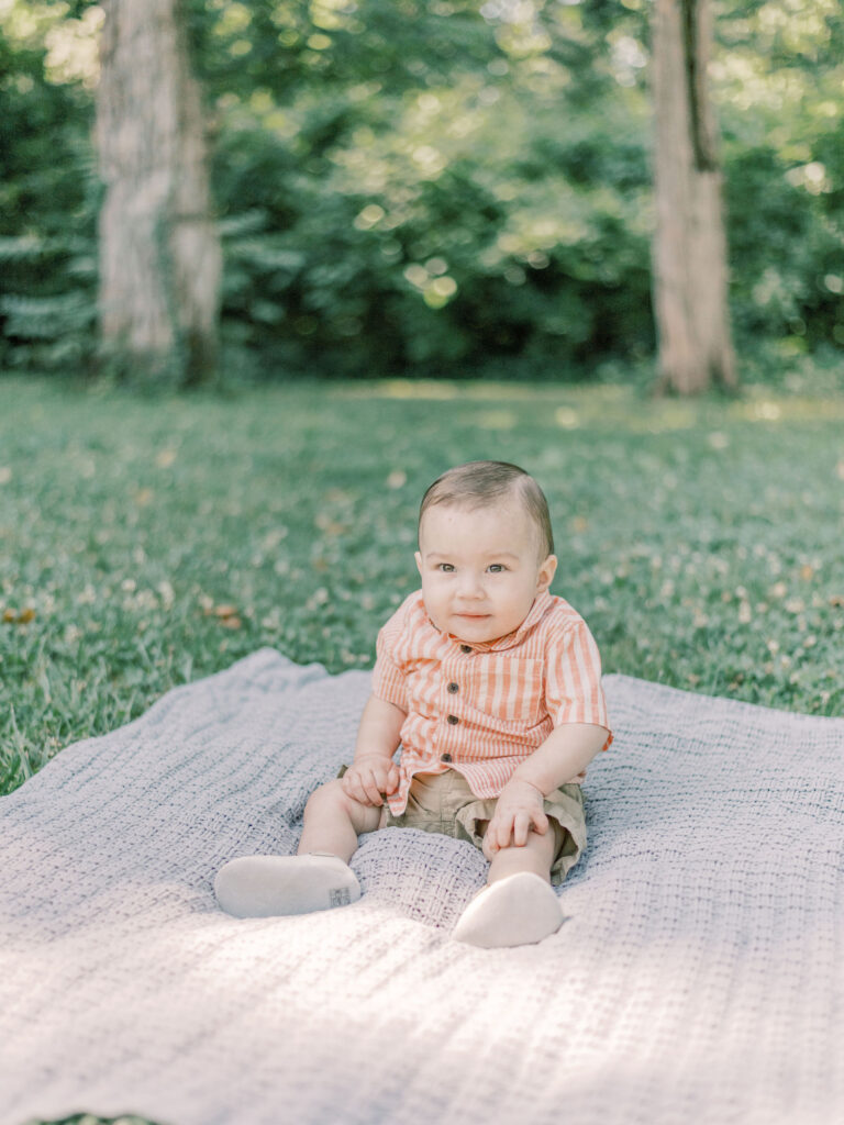 Little boy sitting on blanket during golden hour in Fredericksburg Virginia at Pratt Park.