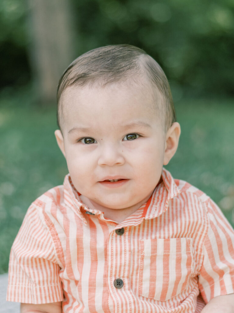 One year old in peach stripped shirt during birthday photo session.