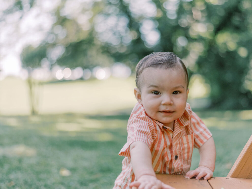 One year old boy wearing peach stripped shirt during his photo session in Fredericksburg Virginia.