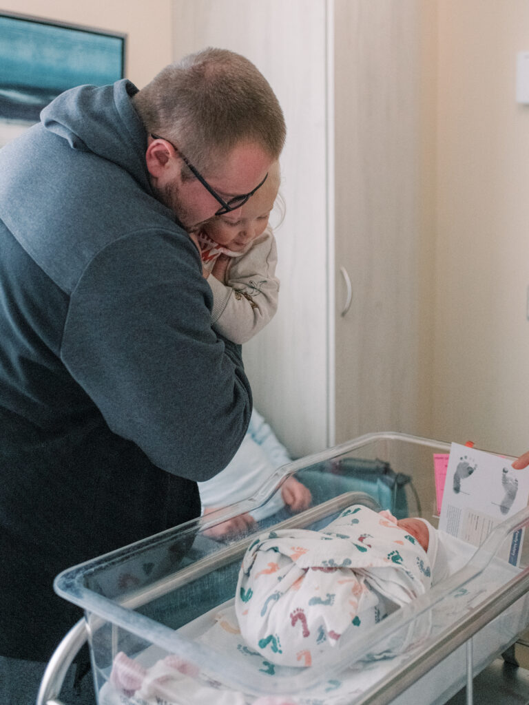 New Dad looking at his newborn daughter for the first time.