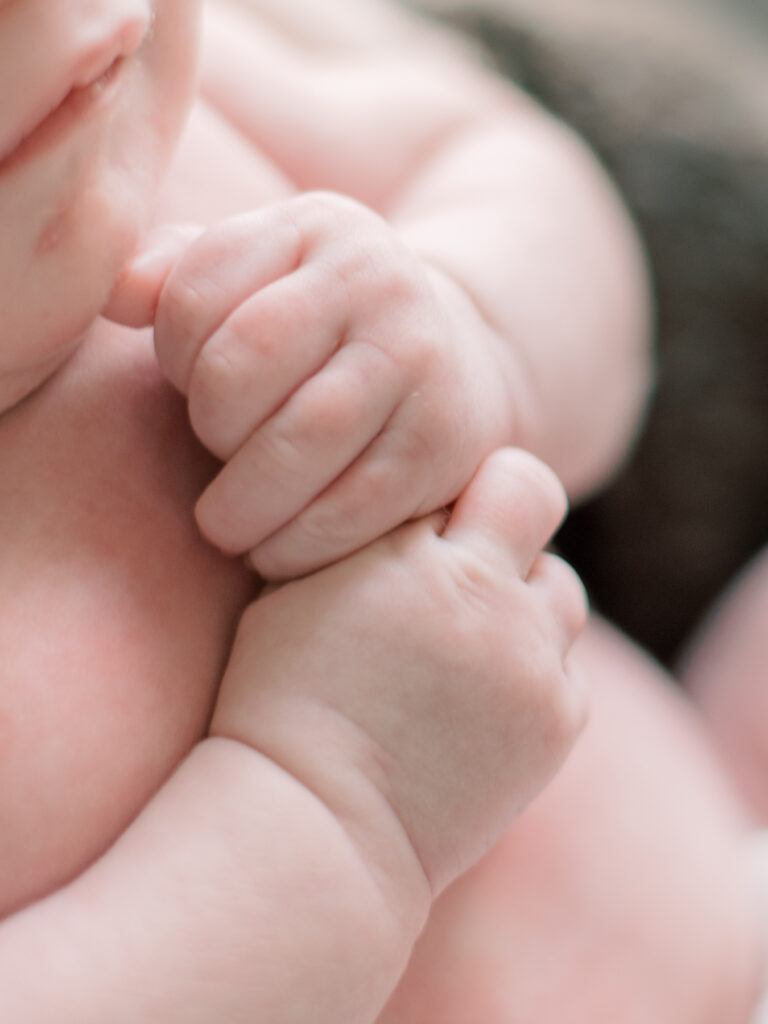 Detail photo of newborn baby hands during a newborn photo session.